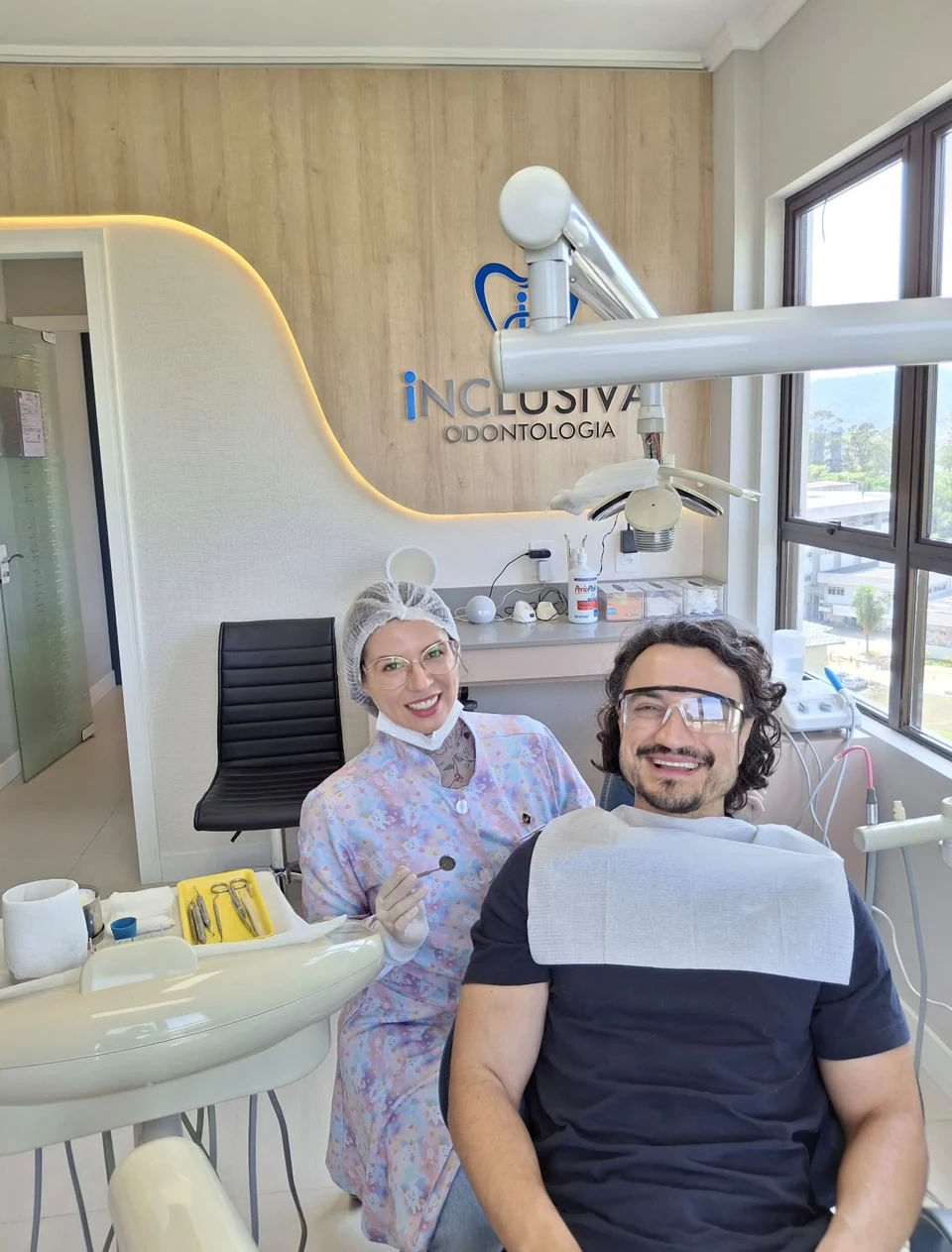 Dra. Aline e paciente sorrindo na cadeira odontológica da Inclusiva