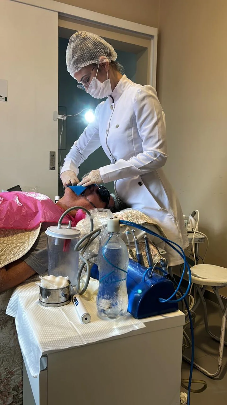 Profissional realizando atendimento odontológico domiciliar com equipamento portátil